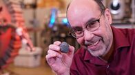 Die Rückkehr zum Mond – Angel Abbud-Madrid, Direktor des Center for Space Resources an der Colorado School of Mines, zeigt eine Asteroiden-Nachbildung.
