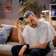 Almania – Der Termin für die Klassenfotos rückt näher, und Stimpel (Phil Laude) fühlt die Notwendigkeit, die Schläfen ein wenig zu rekolorieren. Nicht färben! Rekolorieren!