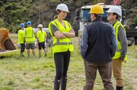 One Lane Bridge – Charlotte (Michelle Langstone, li.) und Haggis McCrae (Phil Brown, re.) besprechen sich mit Maaka (Jim Moriarty, Mi.). Das Ehepaar treibt sein Immobilienprojekt trotz aller Widerstände voran.