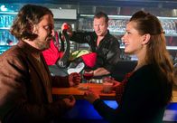 Zwischen den Zeilen – ARD HEITER BIS TÖDLICH - ZWISCHEN DEN ZEILEN, neue Krimi-Komödie mit 16 Folgen, Folge 8 "Majas Filmriss"50 Uhr im Ersten. Maja (Josephine Schmidt, r.) und Freund Johannes (Marian Meder, l.) geben dem Barkeeper (Hanno Friedrich, M.) das Baby zum Aufpassen.