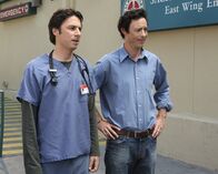 Scrubs - Die Anfänger – Dan (Thomas Cavanagh, r.) möchte sich bei J.D. (Zach Braff, l.) bedanken und schenkt ihm ein Hybridauto, denn ohne ihn wäre er heute nicht derart erfolgreich ...
