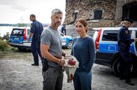 Mord im Mittsommer – Nach ihrem Einsatz beobachten Nora (Alexandra Rapaport) und Alexander (Nicolai Cleve Broch), wie der Rettungswagen losfährt.