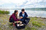 WaPo Bodensee – Katja Hartmann (Matilda Merkel, l.) und Marco Reichert (Silvio Kretschmer, r.) finden am Ufer des Bodensees einen Koffer voller Kokain.