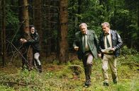 Hubert ohne Staller – Umweltaktivisten (Thorsten Thane, l.) besetzen den Wald des Barons Georg von Waldsee, um ihn vor der Rodung zu bewahren. Hubert (Christian Tramitz, r.) und Girwidz (Michael Brandner, M.) müssen sich mit den Umweltaktivisten auseinandersetzen.