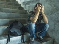 Was ist gut an ... – anti sexual discrimination and against homophobia campaign. Young sad and depressed college student man sitting on staircase desperate victim of harassment suffering bullying and abuse