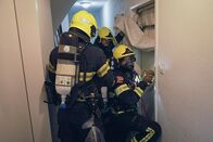 Im Einsatz – Berufsfeuerwehr Basel. Brand hinter verschlosser Türe: Thomas Meyer, Wachtmeister Berufsfeuerwehr Basel (hinten), und sein Team verschaffen sich Zutritt zur Wohnung mit dem Brand ohne zuviel Rauch ins Treppenhaus entweichen zu lassen.