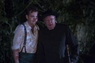 Father Brown – Sid (Alex Price, l.) und Father Brown (Mark Williams, r.) verstecken sich im Wald. Sie beobachten die Dorfbewohner, die sich um einen Stein versammelt haben, um ein geheimes Ritual zu vollziehen.
