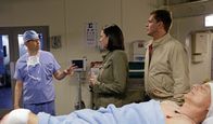 Navy CIS – Nachdem Gibbs (Mark Harmon, liegend) angeschossen wurde, machen sich CIA Officer Joanna Teague (Mimi Rogers, M.) und DiNozzo (Michael Weatherly, r.) großen Sorgen um ihn. Doch Dr. Cyril Taft (Jon Cryer, l.) gibt alles, um ihn zu retten ...