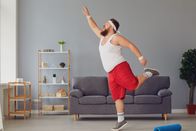 111 – Funny red fat man doing exercises while standing at home