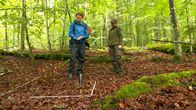 CheXpedition – Kristin zeigt Checker Julian, wieviel Wasser der Waldboden speichert.