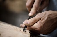 Fast vergessen – Hands of the craftsman carve a bas-relief with a gouge