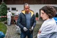 Watzmann ermittelt – Jerry Paulsen (Peter Marton, 2.v.r.) führt mit Conny Haas (Eva-Maria Reichert, r.), der Chefin der Malerfirma, ein erstes Verhör am Tatort. Sonja Bitterling (Genoveva Mayer, im HG. mit Komparse)