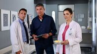 Der Bergdoktor – Gemeinsam mit seinen Kollegen Dr. Alexander Kahnweiler (Mark Keller, l.) und Dr. Vera Fendrich (Rebecca Immanuel, r.) berät Dr. Martin Gruber (Hans Sigl, M.), wie er bei seinem Patienten weiter vorgehen soll.