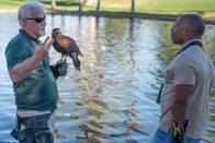 Vogelwild mit Christian Cooper – Christian Cooper trifft sich in einem Park in Palm Springs, Kalifornien, mit dem erfahrenen Falkner Ken Miknuk und seinem treuen Kumpel Bond, einem dressierten Harris'Äô Hawk. Ken wird von der Stadtverwaltung beauftragt, Bond zu fliegen, um die Schwarzscheitelreiherpopulation sicher von den Bäumen zu vertreiben. (National Geographic/Jon Kroll)