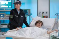 In aller Freundschaft – Eine Beamtin (Komparsin) überwacht Gefängnisinsassin Monika Vietmann (Anna Thalbach), die trotz starker Bauchschmerzen jede weitere Diagnostik verweigert.