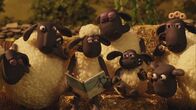 Shaun das Schaf – Shaun liest ein Buch über Drachen vor und die Schafe hören gespannt zu.
