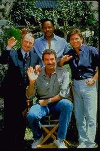 Magnum – Beim Lösen seiner Fälle helfen Thomas Magnum (Tom Selleck, M.) immer wieder T.C. Calvin (Roger E. Mosley, hinten M.), Strandclubbesitzer Rick Wright (Larry Manetti, r.) und der gestrenge Hausverwalter Jonathan Higgins (John Hillerman, l.) ...