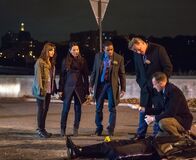 Elementary – Ein neuer Fall wartet auf das Team: (v.l.n.r.) Kitty (Ophelia Lovibond), Watson (Lucy Liu), Detective Bell (Jon Michael Hill), Captain Gregson (Aidan Quinn) und Holmes (Jonny Lee Miller) ...