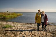Inga Lindström: Liebe lebt weiter – Nachdem Britta (Cornelia Ivancan, l.) ihre jährliche Flaschenpost an ihren verstorbenen Verlobten Matti gerichtet, ins Meer auf Reisen geschickt hat, trifft sie Lilja (Christine Schorn, r.), die sie zum Bleiben einlädt. in Verbindung mit der Sendung bei Nennung ZDF/Arvid Uhlig