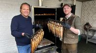 Der Vorkoster – Spitzenkoch Björn Freitag (l.) und Fischwirt Philipp Stobbe (r.) holen den heißgeräucherten Lachs aus dem Räucherofen.