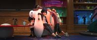 Baymax - Riesiges Robowabohu – V.r.: Honey Lemon, Fred, GoGo und Wasabi chillen eine Runde auf dem luftgepolsterten Roboter Baymax und genießen dessen Wärmefunktion, während Hiro verbissen einer Spur folgt.