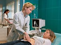 In aller Freundschaft – ", Regie: Peter Wekwerth Uhr im Ersten. Jutta Müller (Tatjana Blacher, re.) ist nach dem Lauftraining zusammengebrochen und lässt sich nun auf Drängen ihres Sohnes Holger in der Sachsenklinik von Dr. Kathrin Globisch (Andrea Kathrin Loewig, li.) untersuchen.