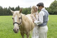 Sturm der Liebe – Viktor (Sebastian Fischer, r.) ist überglücklich, Alicia (Larissa Marolt, l.) endlich in die Arme schließen zu können. Pferd Taifun begleitet das Brautpaar.