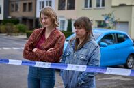 Mord mit Aussicht – Vivien (Rebekka Wurst, l.) und Jenny (Eva Bühnen, r.) stehen hinter der Polizeiabstimmung und schauen bedrückt auf den Fundort der Leiche.