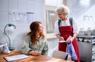 Sturm der Liebe – Hildegard (Antje Hagen, r.) gibt Fanny (Johanna Graen, l.) die Karte für Werner zum Unterschreiben.
