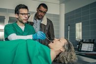 SOKO München – Franz Ainfachnur (Christofer v. Beau, m.) schaut zu, wie Dr. Weissenböck (Florian Odendahl, l.) die Leiche von Frau Prof. Hochwald (Melanie Wiegmann, r.) untersucht.
