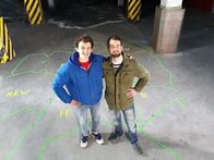 Checker Julian – Checker Julian mit Sprachforscher Simon Pröll (rechts) in Dachau auf der selbst gebastelten "Dialektlandkarte".