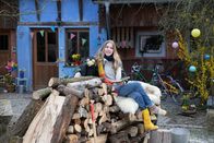 Rabe Rudi - Vorlese-Geschichten – Milena Tscharntke und Rabe Rudi sitzen nebeneinander auf einem Holzstapel und lächeln in die Kamera.