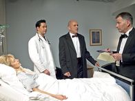 In aller Freundschaft – Gunter Mensing (Klaus Schindler, Mitte) will sich bei Roland Heilmann (Thomas Rühmann, rechts) bedanken. Doch der verweist ihn an Evelyn Mensings (Cay Helmich, liegend) behandelnden Arzt Dr. Philipp Brentano (Thomas Koch).