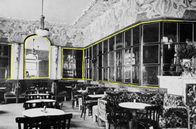 Geschichte schreiben – Archivfoto eines mit Spiegeln verzierten Raumes: Das 19. Jahrhundert bringt den Wandel in der Geschichte des Spiegels. So zahlreich wie nie zuvor sind sie in Kaufhäusern, Cafés, Frisiersalons und Bekleidungsgeschäften zu finden.