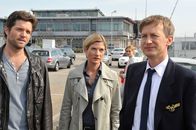 SOKO Stuttgart – Jo Stoll (Peter Ketnath, l.) und seine Chefin Martina Seiffert (Astrid M. Fünderich, 2.v.l.) befragen den Piloten Kai-Uwe Maassen (Jan Henrik Stahlberg, r.) am Flughafen dazu, warum er ein falsches Alibi angegeben hat. Ihm ist die Befragung unangenehm, da seine Frau Bea (Komparsin, 2.v.r.) im Hintergrund steht.