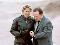 Tatort – Kommissar Ehrlicher (Peter Sodann) stützt Christine Werrling (Barbara-Magdalena Ahren): Die Professorin mußte mit ansehen, wie ihr Freund Robert einen Motorradunfall erlitt und nun regungslos im Sand liegt.