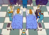 Die Simpsons – Homer (l.) wird auf eine Operation vorbereitet, weil er seinem Vater eine Niere spenden soll. Allerdings nimmt Homers egoistisches Wesen im letzten Augenblick überhand, und statt die Niere zu spenden, macht sich Homer auf und davon.