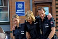 Notruf Hafenkante – Erleichtert darüber, dass die Geiselnahme ein gutes Ende genommen hat, verlassen Franzi (Rhea Harder, l.), Melanie (Sanna Englund, M.) und Kai (Markus Knüfken, r.) das PK 21.