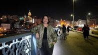 Megacitys - Wenn es Nacht wird in ... – Phoebe Gaa steht auf einer der Brücken in Istanbul und schaut lächelnd in die Kamera. Im Hintergrund liegt die Stadt bei Nacht.