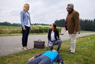 Die Rosenheim-Cops – Dass der tödlich verunglückte Jogger (Komparse) dem herannahenden Fahrzeug offenbar nicht ausgewichen ist, lässt für die Kommissare Winter (Vanessa Eckart, l.), Pathologin Mai (Sina Wilke, M.) und Kommissar Stadler (Dieter Fischer, r.) nur einen Schluss zu: Er hat Kopfhörer getragen.