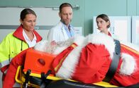 In aller Freundschaft – Dr. Kai Hoffmann (Julian Weigend, mi.) hat Dr. Maria Weber (Annett Renneberg, re.) gerade seinen Unmut über die Existenz des Weihnachtsfestes kundgetan, als die Notärztin (Caren Seifert, li.) einen Weihnachtsmann (Armin Dallapiccola, liegend) einliefert. Ausgerechnet beim Weihnachtsbaum schmücken ist dieser von der Leiter gefallen. Kai fällt sofort der Alkoholgeruch auf.