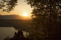 Servus Reportage – Das Bild zeigt ein Pärchen beim genießen des Sonnenuntergangs am Faaker See.
