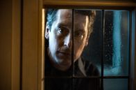 Tatort – Dr. Jens Jacoby (Hans Löw) schaut durch ein Fenster in ein Lokal.