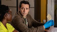 Death in Paradise – Im Polizeirevier untersuchen Naomi Thomas (Shantol Jackson, l.) und Detective Neville Parker (Ralf Little, r.) akribisch einen Zettel mit einem Hilferuf und führen entsprechende Nachforschungen durch.