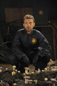 Bones - Die Knochenjägerin – Hodgins (T.J. Thyne) stellt erstaunt fest, dass der verweste Körper mit Pilzen übersäht ist, die scheinbar auf dem Leichnam gezüchtet wurden.