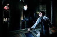 Saw VI – Der rücksichtlose Manager einer Versicherungsgesellschaft, William Easton (Peter Outerbridge, vorne), wird gezwungen, Jigsaws Plan posthum zu erfüllen. Er muss, um überleben zu können, sechs ebenso kaltherzige wie hilflose Untergebene an diesem tödlichen Spiel beteiligen ...