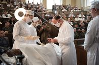 Charité – Die Wochenschau filmt: Prof. Sauerbruch (Ulrich Noethen, 2.v.r.) operiert den Oberschenkel von Lohmann (Ludwig Simon), assistiert von seiner Frau Margot (Luise Wolfram, l.), Schwester Christel (Frida-Lovisa Hamann, 2.v.l.) und Pfleger Martin Gruber (Jacob Matschenz, r.).