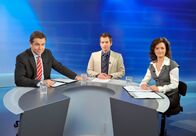 Der Winzerkönig – ARD/SWR DER WINZERKÖNIG III. STAFFEL, FOLGE 38, "Neue Wege" Uhr im ERSTEN. Im Studio bei der entscheidenden Fernsehdiskussion zur Bürgermeisterwahl (v.li.): Georg Plattner (Stefan Fleming), Moderator (Martin Ganster) und Andrea Plattner (Katharina Stemberger).