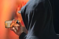 Puls – Mann mit Hoodie, der auf seinem Smartphone pornografische Inhalte konsumiert.