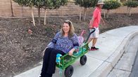 Die Fußchirurgen – Alisha Williams being pulled by companion in Wagon